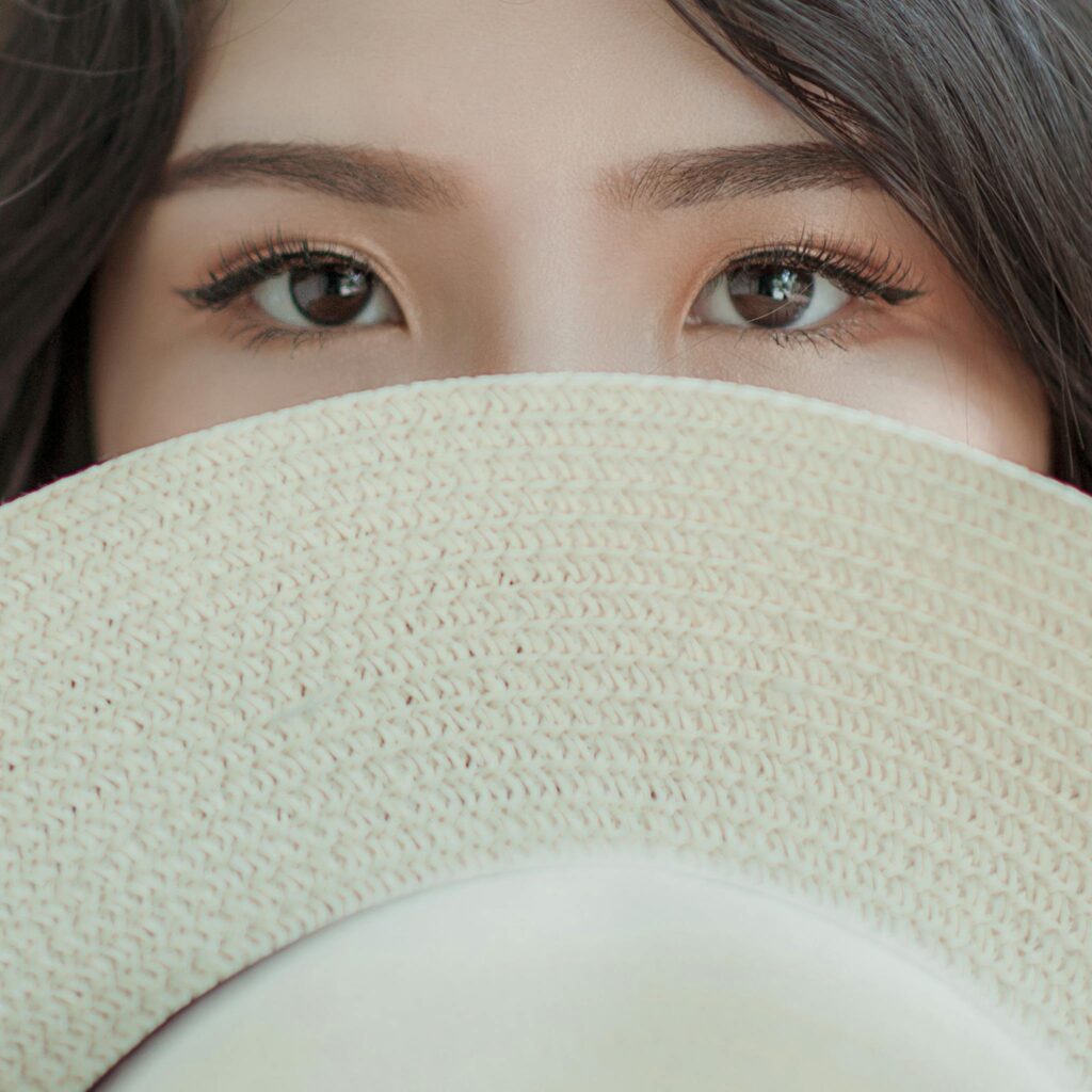 Person Covering Face With Hat Photo